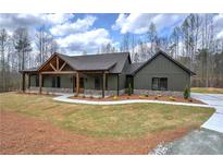 Charming home featuring a decorative wood gable, stone accents, and a welcoming walkway, set on a well-manicured lawn at 313 Morgan Rd, Temple, GA 30179