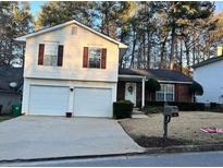 Charming two-story home boasts a two-car garage, manicured lawn, and welcoming front entrance at 709 Kilkenny Cir, Lithonia, GA 30058