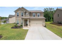 Charming two-story home with a well-manicured lawn and a two-car garage in a suburban neighborhood at 485 Auburn Crossing Dr, Auburn, GA 30011