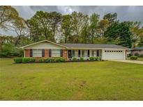 Charming one-story brick home with manicured lawn and tasteful landscaping and black shutters at 1283 Maple St, Conyers, GA 30013