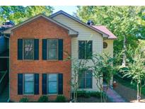 Charming two-story townhome with a mix of brick and siding exterior and black shutters at 202 Garden Ct, Atlanta, GA 30328