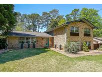 Charming two-story brick home featuring a well-manicured lawn and vibrant green trees at 3530 Embry Cir, Atlanta, GA 30341