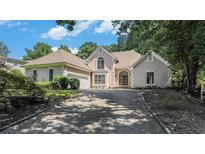 Charming home featuring a stone facade, arched entryway, and well-manicured landscaping, creating an inviting curb appeal at 370 Royal Birkdale Ct, Johns Creek, GA 30097