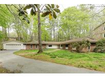 Ranch-style home featuring a brick facade, well-manicured lawn, and a long driveway at 5130 N Peachtree Rd, Dunwoody, GA 30338