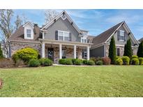 Charming two-story home features a welcoming front porch and beautifully landscaped front yard at 1344 Chipmunk Forest Chase, Powder Springs, GA 30127
