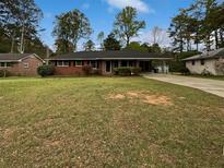Charming brick ranch home with a large front yard and mature trees at 1899 Stratford Arms Dr, Morrow, GA 30260