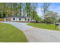 Beautifully renovated home featuring a long driveway and lush green lawn at 3805 Cloudland Se Dr, Smyrna, GA 30082