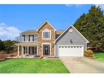 Charming two-story home with stone accents, gray siding, and a well-manicured lawn at 2758 Adair Trl, Dacula, GA 30019