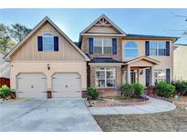Charming two-story home with a well-manicured lawn, two-car garage, and inviting curb appeal at 4463 Grove Lake St, Loganville, GA 30052