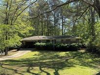 Cozy single story brick home with mature landscaping, a carport and a long driveway at 2903 Vogue Dr, Douglasville, GA 30134