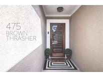 Inviting entryway featuring a modern wood door, sleek black and white rug, and stylish potted plants at 475 Brown Thrasher Ct, Alpharetta, GA 30009