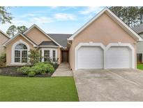 Charming single-Gathering home featuring a two-car garage, manicured lawn, and inviting walkway at 475 Brown Thrasher Ct, Alpharetta, GA 30009