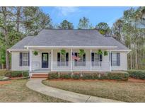 Charming single-story home featuring a welcoming front porch with a white picket fence and black shutters at 60 Riverside Pkwy, Sharpsburg, GA 30277