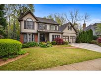 Charming two-story home featuring manicured lawn, brick accents, and an attached two-car garage at 4688 Oakleigh Manor Dr, Powder Springs, GA 30127