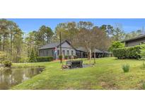 Beautiful single-Gathering home featuring large lawn, pond and covered patio perfect for entertaining at 6585 Queen Mill Se Rd, Mableton, GA 30126