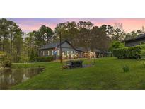 Charming home featuring a well-manicured lawn, mature trees, and a serene pond, perfect for outdoor enjoyment at 6585 Queen Mill Se Rd, Mableton, GA 30126
