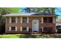 Charming brick home featuring a well-maintained lawn, white shutters, and a classic front door at 1464 Colony East Cir, Stone Mountain, GA 30083