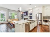 Open kitchen and living room with stainless appliances, kitchen island, and a cozy fireplace at 828 Canterbury Overlook Ne, Atlanta, GA 30324