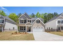 New construction home showcasing its manicured front yard, two-car garage, and brick accents at 13918 Homer Ln, Covington, GA 30014