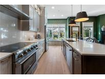 Gourmet kitchen features stainless steel appliances, custom cabinetry, and a large center island with bar seating at 2630 Milford Ln, Alpharetta, GA 30009