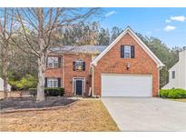 Charming two-story brick home with a two-car garage and a well-manicured front yard at 5775 Stephens Mill Dr, Sugar Hill, GA 30518