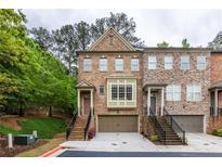 Charming brick townhome with a two-car garage and professionally landscaped front yard at 2528 Magnolia Ridge Dr, Marietta, GA 30067