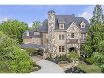 Stunning stone and brick home with a porte-cochere and professionally landscaped front yard at 854 Club Moss Ct, Marietta, GA 30068