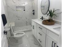 Modern bathroom features sleek white marble tile, a spacious walk-in shower, and elegant black fixtures at 1841 Bayberry Sw Dr, Atlanta, GA 30311