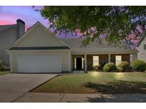 Charming single-story home featuring a well-manicured lawn, attached garage, and mature trees at 2793 Saddle Horn, Snellville, GA 30039