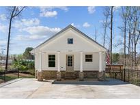 Charming single-story home featuring a gabled roof, white siding, and inviting brick-base front porch at 3143 Lee Cir, Buford, GA 30518