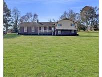 Charming brick home with a sprawling green lawn and inviting front porch at 3415 Spot Rd, Cumming, GA 30040