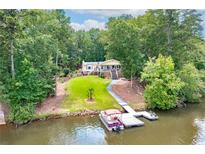Lakefront home with a private dock and lush green lawn stretching to the water's edge at 590 Yancey Cir, Covington, GA 30014