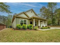 Charming craftsman-style home with green siding, well-manicured lawn, and inviting front porch at 9117 Dearing St, Covington, GA 30014