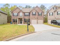 Charming two-story brick home with a well-manicured lawn and a two-car garage at 3443 Woodshade Dr, Loganville, GA 30052