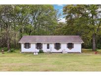 Charming one-story home featuring a manicured lawn and lovely curb appeal with a water fountain feature at 419 Fincher Rd, Covington, GA 30016