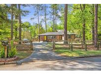 Charming brick home featuring a welcoming driveway and mature trees, creating a serene and private setting at 3385 Pinehill Dr, Decatur, GA 30032