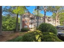 Charming condo with brick and vinyl siding, surrounded by lush greenery and mature trees at 340 Teal Ct, Roswell, GA 30076