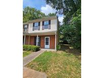 Charming townhome featuring brick facade, manicured lawn, and inviting front entrance at 1557 Springleaf Se Ct, Smyrna, GA 30080