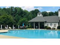 Relaxing pool with a covered area that offers shaded seating and a perfect view of the lush greenery at 4062 Vinings Mill Se Trl, Smyrna, GA 30080