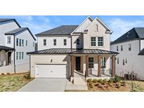 Charming two-story home featuring a covered porch, two-car garage, and classic architectural details at 784 Keystone Dr, Woodstock, GA 30188