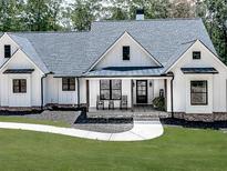 Charming white farmhouse with inviting porch and manicured lawn in a tranquil setting at 1170 Upper Sweetwater Se Trl, White, GA 30184