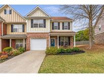 Charming two-story home featuring brick accents, a well-manicured lawn, and an attached one car garage at 4037 Hill Station Ct, Sugar Hill, GA 30518