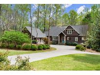 Charming craftsman-style home boasts meticulous landscaping, a circular driveway, and a striking blue front door at 208 Greenhill Dr, Dallas, GA 30157