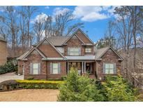 Charming brick home featuring manicured landscaping, a well-kept lawn, and a covered entryway at 1190 Mosspointe Dr, Roswell, GA 30075