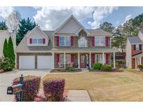 Charming two-story home with a well-manicured front yard, stone accents, red shutters and a welcoming front porch at 3904 Tristan Way, Suwanee, GA 30024