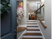 Inviting entryway with hardwood stairs and railing leads to the open concept living area at 62 Emerson Hill Sq, Marietta, GA 30060