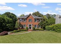 Charming two-story brick home with a well-manicured lawn and a welcoming front entrance at 1811 Tilliewood Ne Trl, Marietta, GA 30066