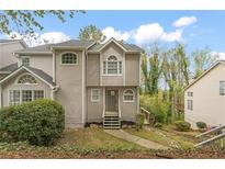 Charming multi-level home boasts a manicured lawn, gray siding, and a welcoming front entrance at 1663 Paddlewheel Dr, Marietta, GA 30062
