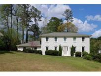 Traditional two-story home with a painted brick facade, well-manicured lawn, and classic architectural details at 3811 Valley Green Dr, Marietta, GA 30068