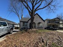 Charming brick home featuring arched porch, landscaped yard, and mature shade tree at 880 Westmont Sw Rd, Atlanta, GA 30311